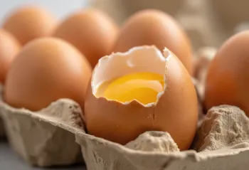 Brotið hrátt egg með rauðu og hvítu á trébretti