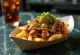 Poutine með rifnu grísakjöti í kanadískum stíl borið fram