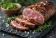 Iberico pork secreto served with lemon wedges and grilled vegetables.